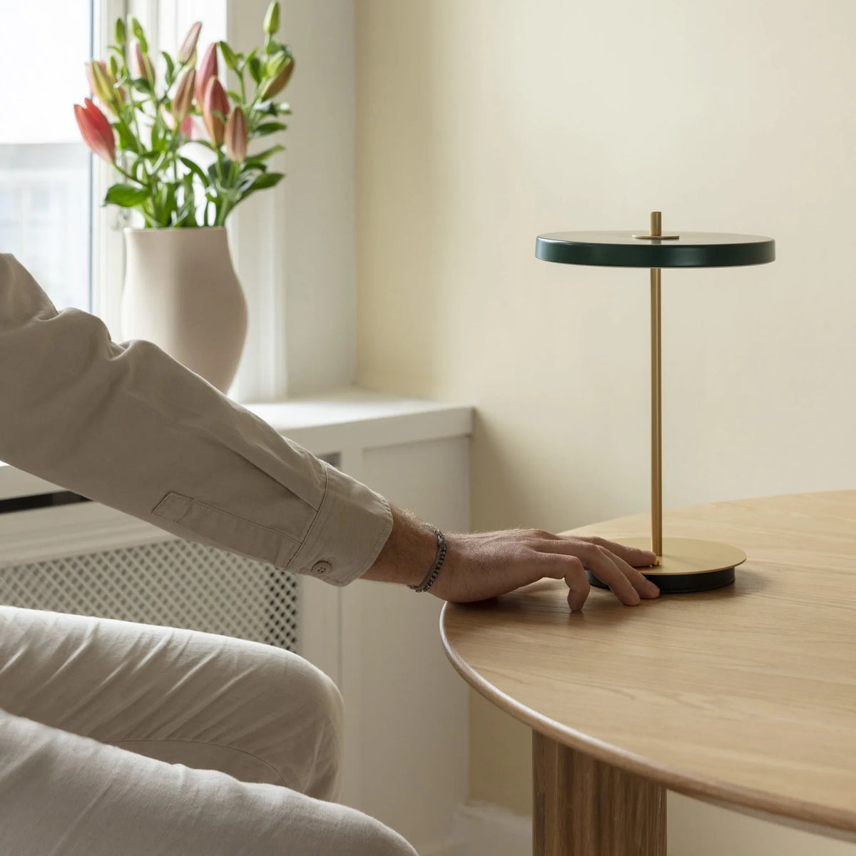 Cordless rechargeable LED table lamp, brass base, in use at home