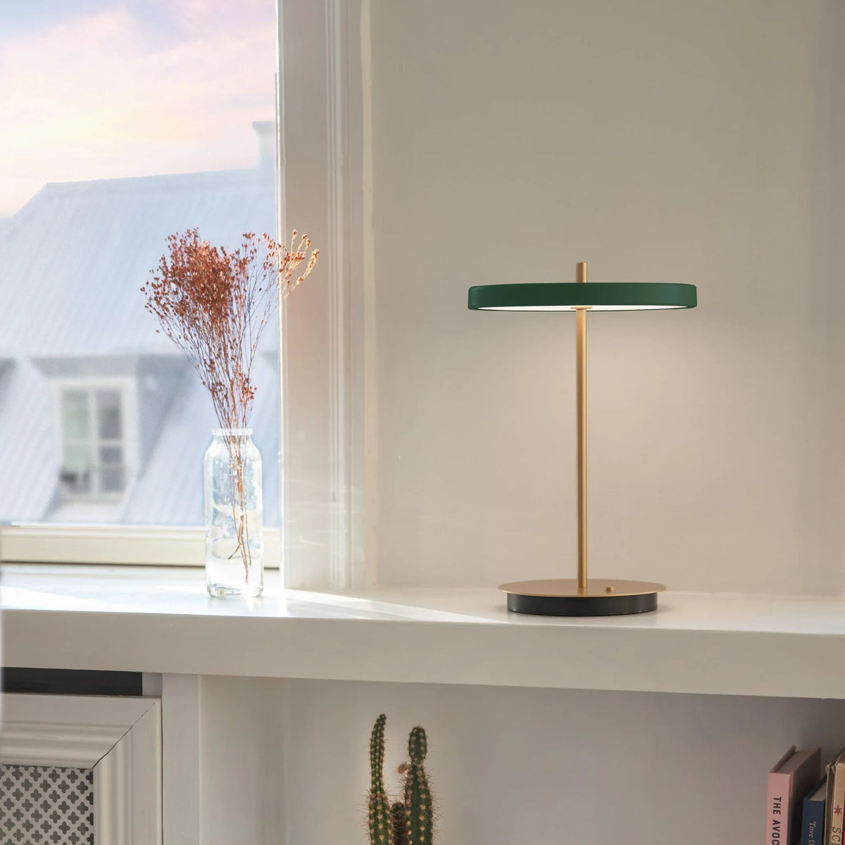 Cordless rechargeable LED table lamp, brass base, in use at home