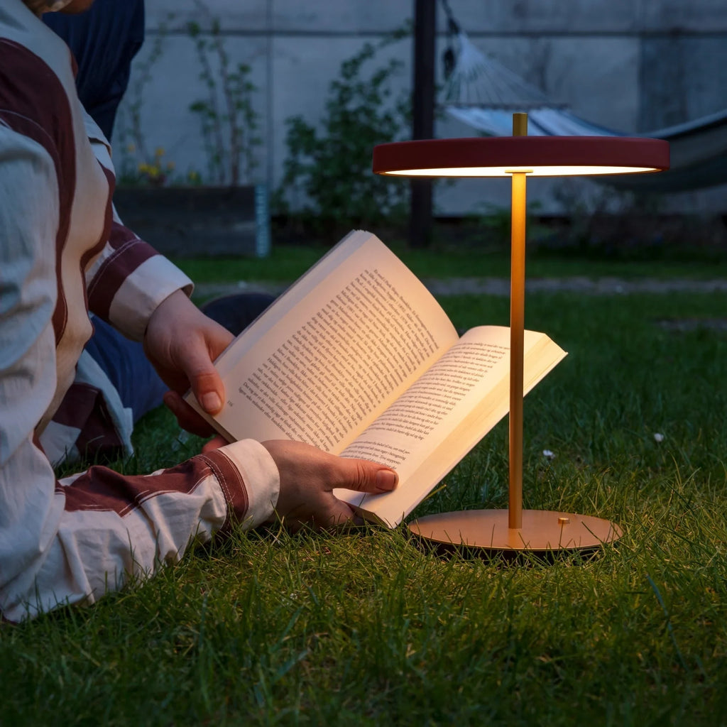 Cordless rechargeable LED table lamp, brass base, in use at home