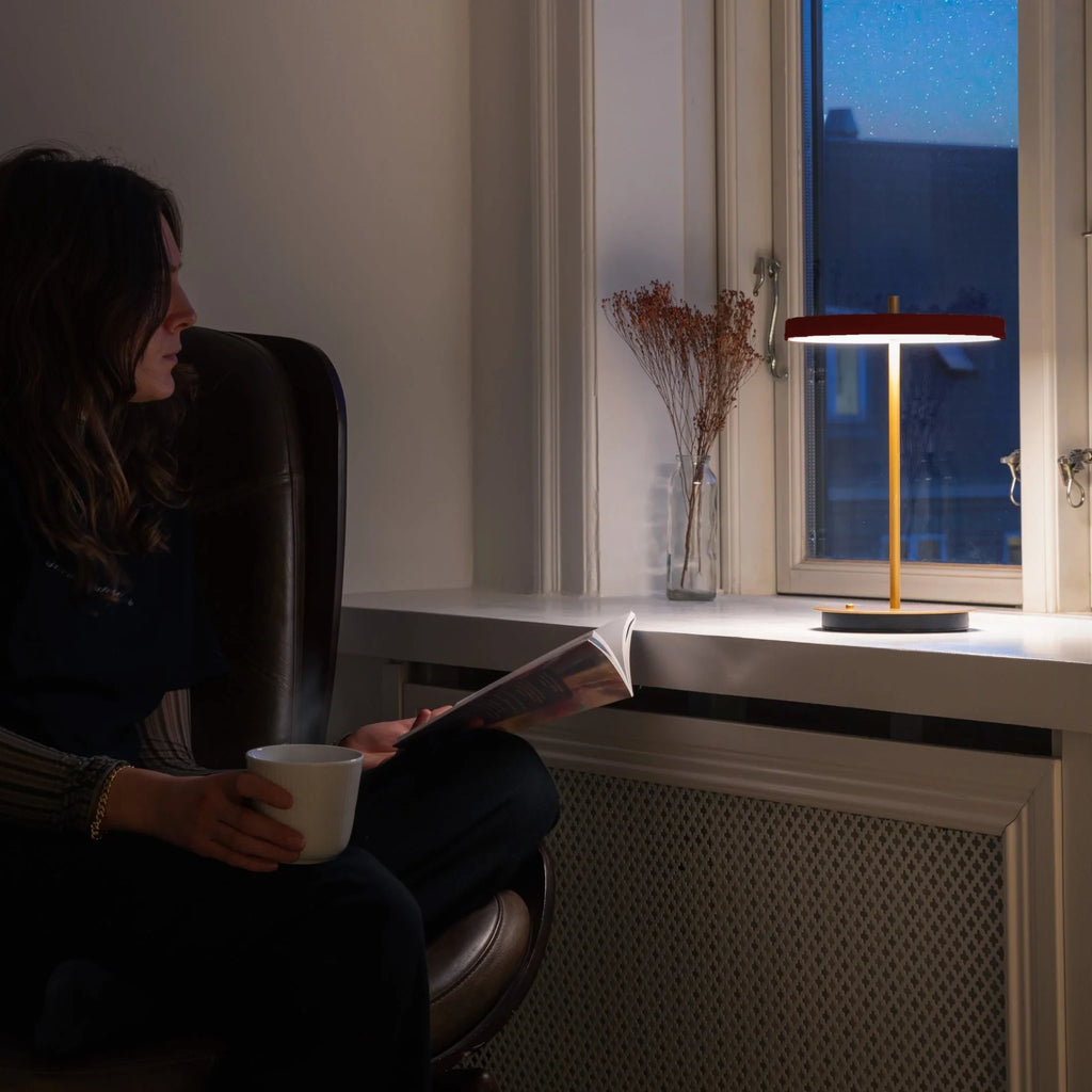 Cordless rechargeable LED table lamp, brass base, in use at home