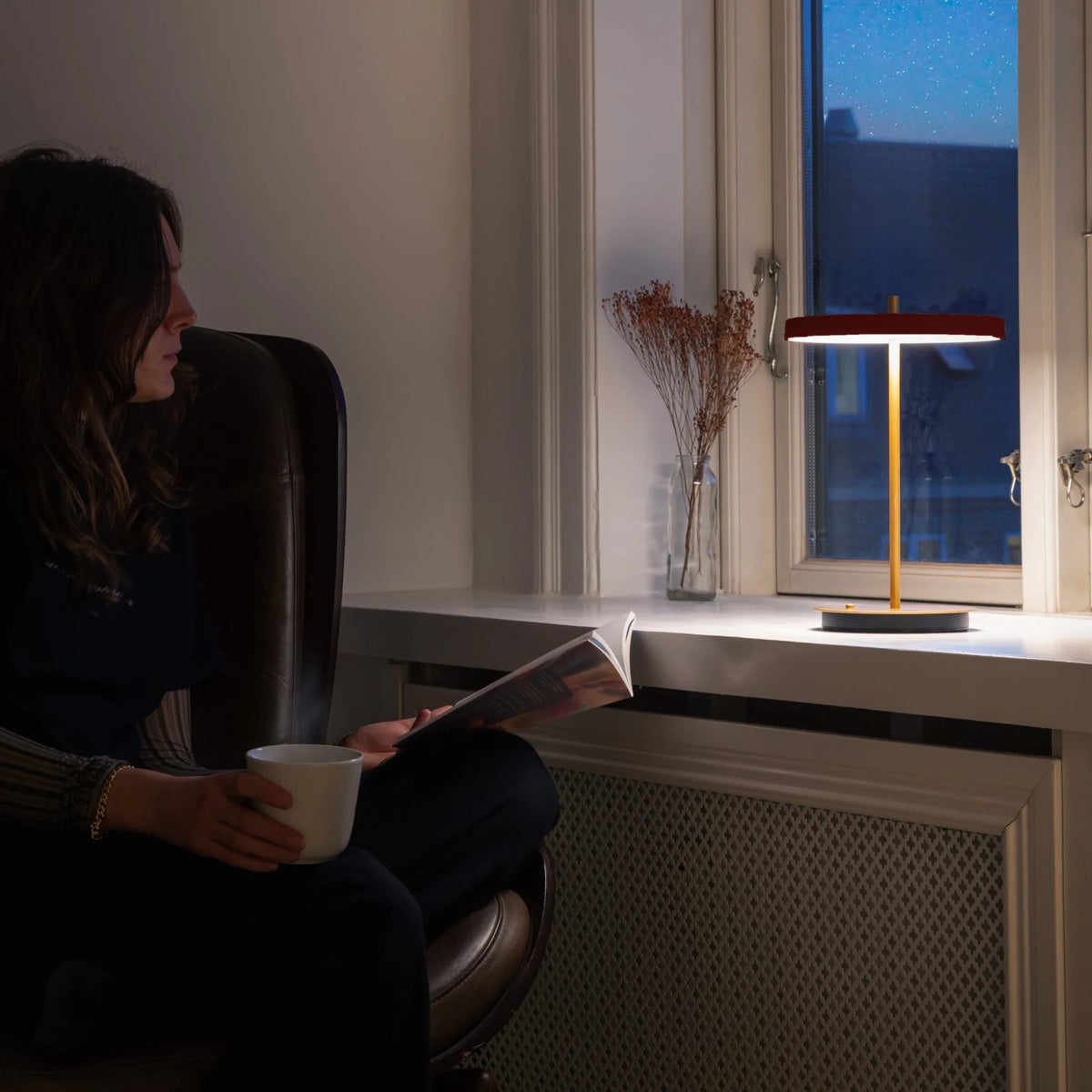 Cordless rechargeable LED table lamp, brass base, in use at home