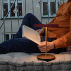 Cordless rechargeable LED table lamp, brass base, in use at home