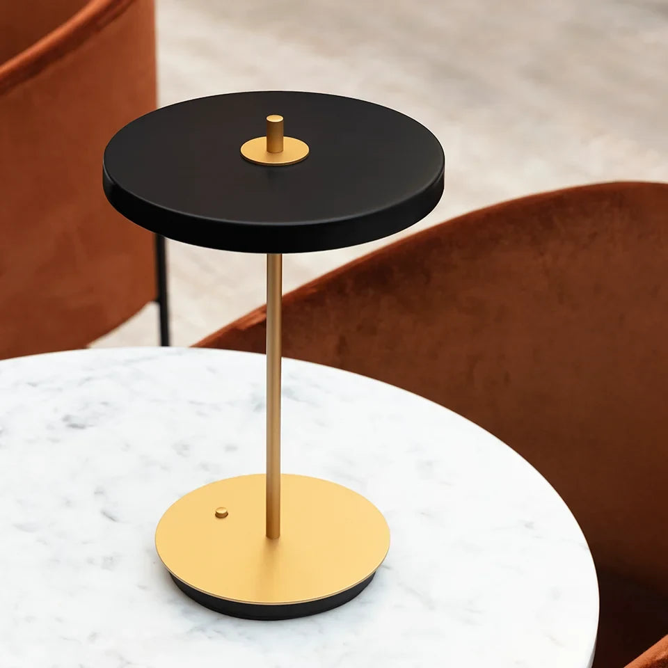 Cordless rechargeable LED table lamp, brass base, in use at home