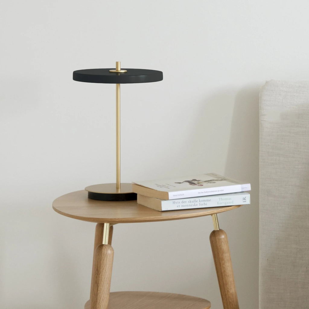 Cordless rechargeable LED table lamp, brass base, in use at home