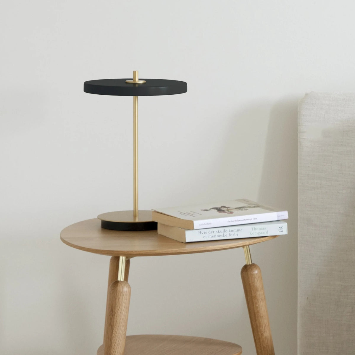 Cordless rechargeable LED table lamp, brass base, in use at home