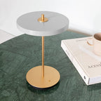 Cordless rechargeable LED table lamp, brass base, in use at home