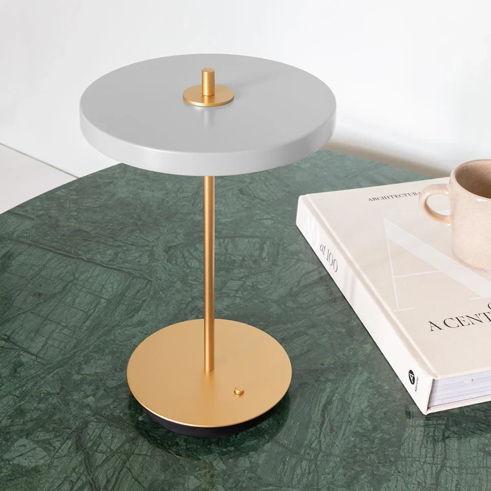 Cordless rechargeable LED table lamp, brass base, in use at home