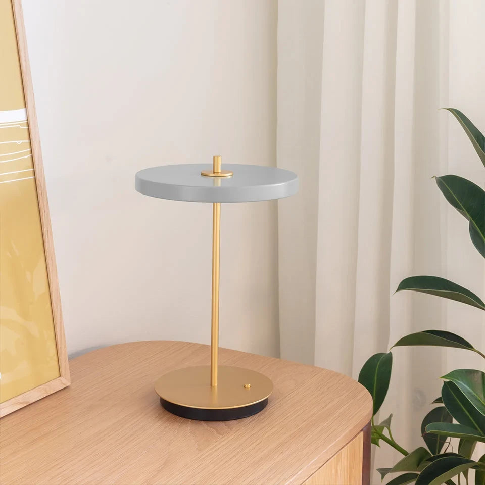 Cordless rechargeable LED table lamp, brass base, in use at home
