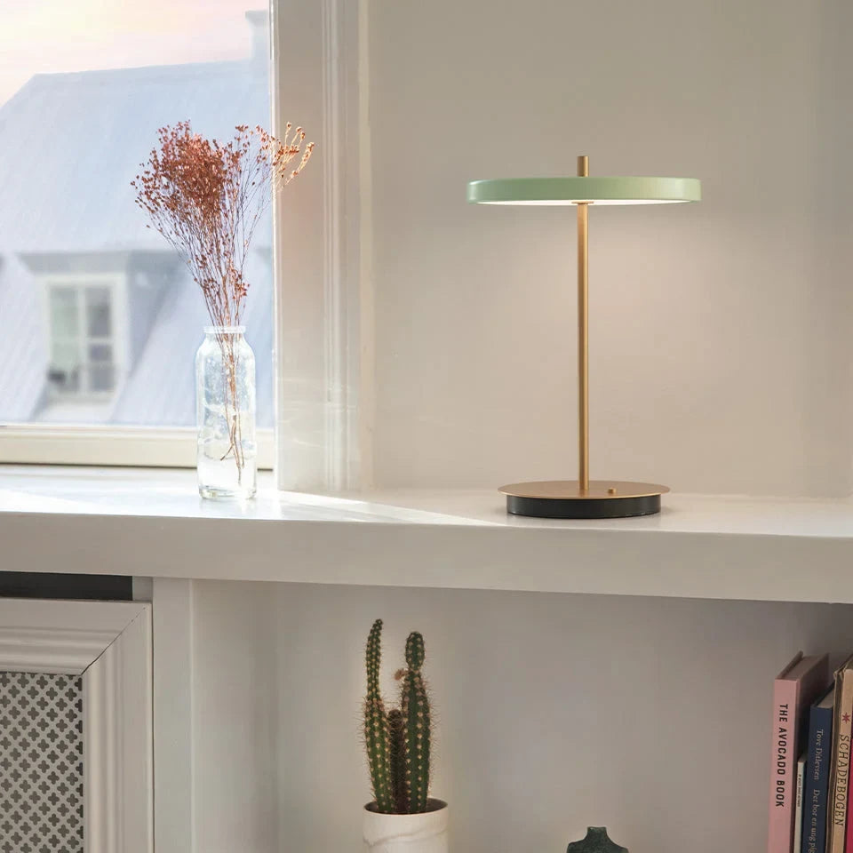 Cordless rechargeable LED table lamp, brass base, in use at home