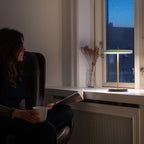 Cordless rechargeable LED table lamp, brass base, in use at home