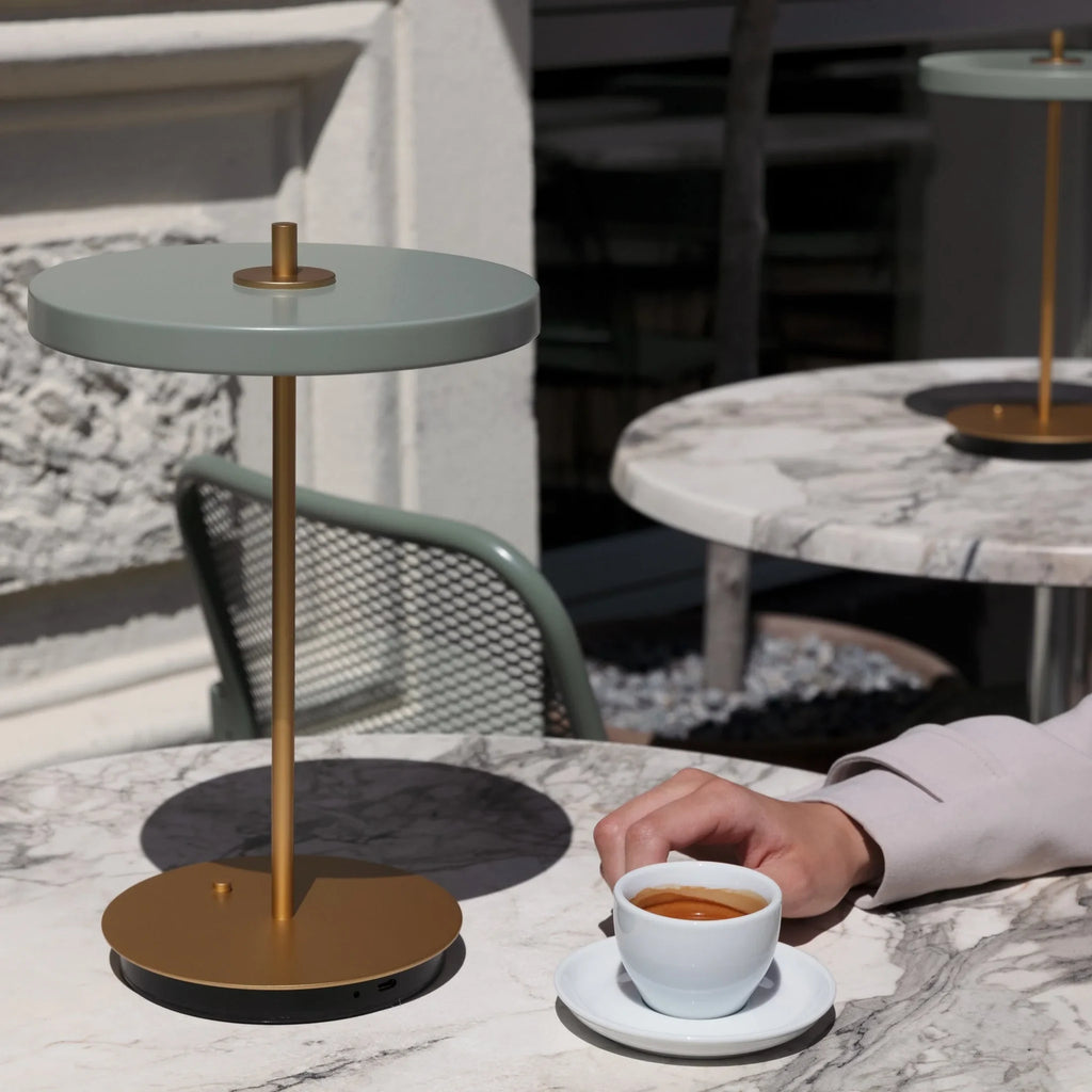 Cordless rechargeable LED table lamp, brass base, in use at home
