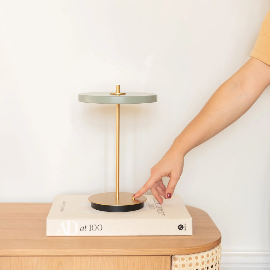 Cordless rechargeable LED table lamp, brass base, in use at home