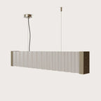 Corrugated linear bar pendant, with pale sheets on a plain background
