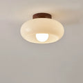 Cream glass flush ceiling light, lit, close-up
