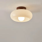 Cream glass flush ceiling light, lit, close-up