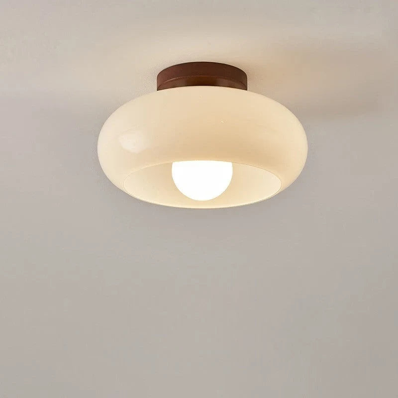 Cream glass flush ceiling light, lit, close-up