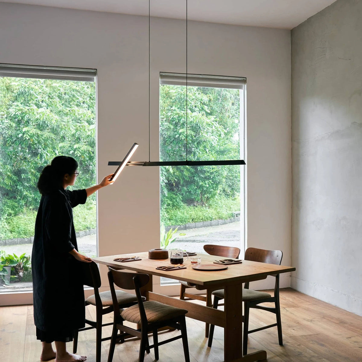 Crossed bar linear LED pendant, above a dining table