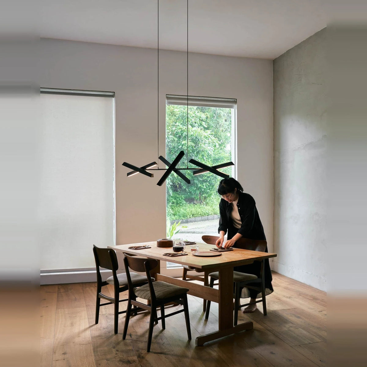 Crossed bar linear LED pendant, above a dining table, angled bars