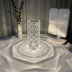 Crystal-effect cordless table lamp, lit, casting patterns on a table