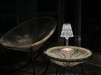 Crystal-effect rechargeable table lamp, lit on a glass table at night