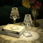 Crystal-effect rechargeable table lamp, a pair lit on a stack of books