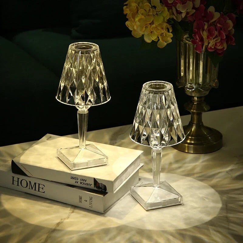 Crystal-effect rechargeable table lamp, a pair lit on a stack of books
