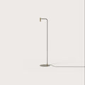 Curved-arm task floor lamp, with a matte brass head, on a plain background