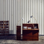 Curved beech arm steel table lamp, in Black and Grey on a wooden desk