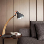 Curved beech arm steel table lamp, in Black on a side table by a sofa