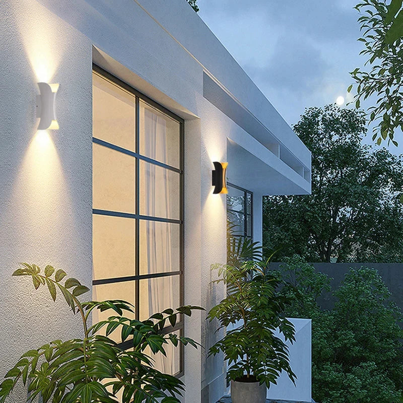 Curved up and down outdoor wall light, lit on a wall