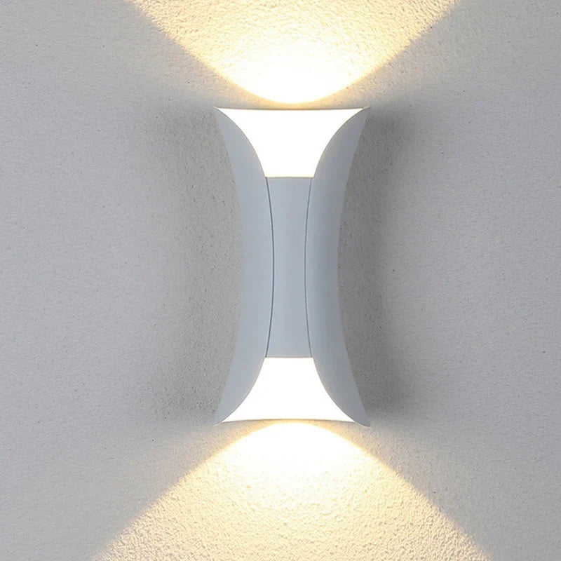 Curved up and down outdoor wall light, lit on a wall