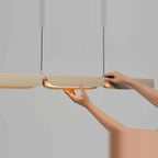 Curved shade linear LED pendant, shade being adjusted by hand