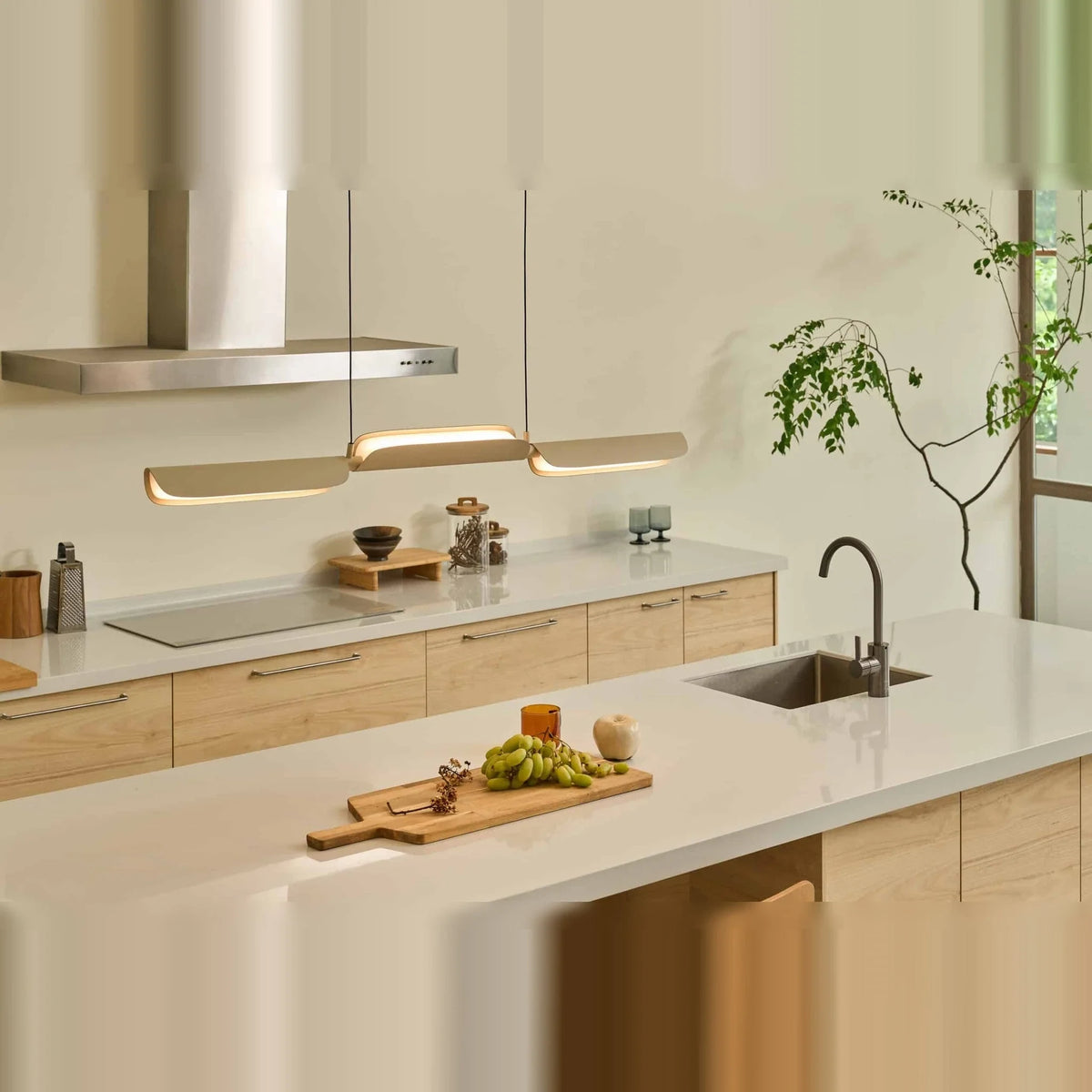 Curved shade linear LED pendant, above a kitchen worktop