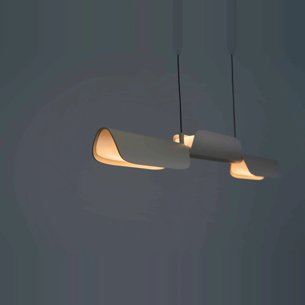 Curved shade linear LED pendant, in oatmeal against a dark wall