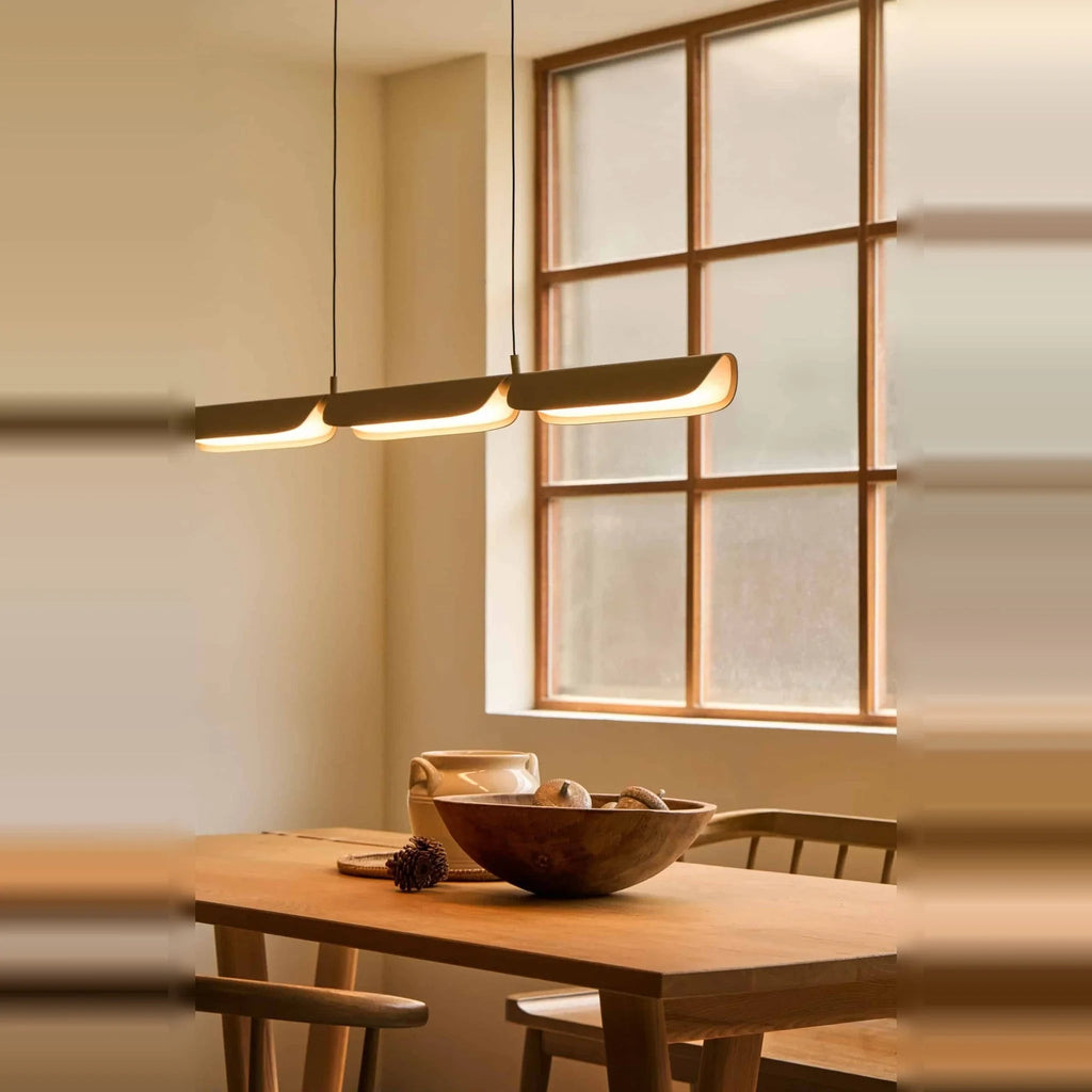 Curved shade linear LED pendant, above a dining table
