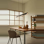 Curved shade linear LED pendant, above a table by a window