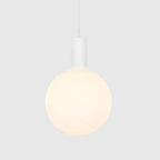 Cylinder pendant with matt white globe bulb, chalk, bulb at a warm dimmed setting