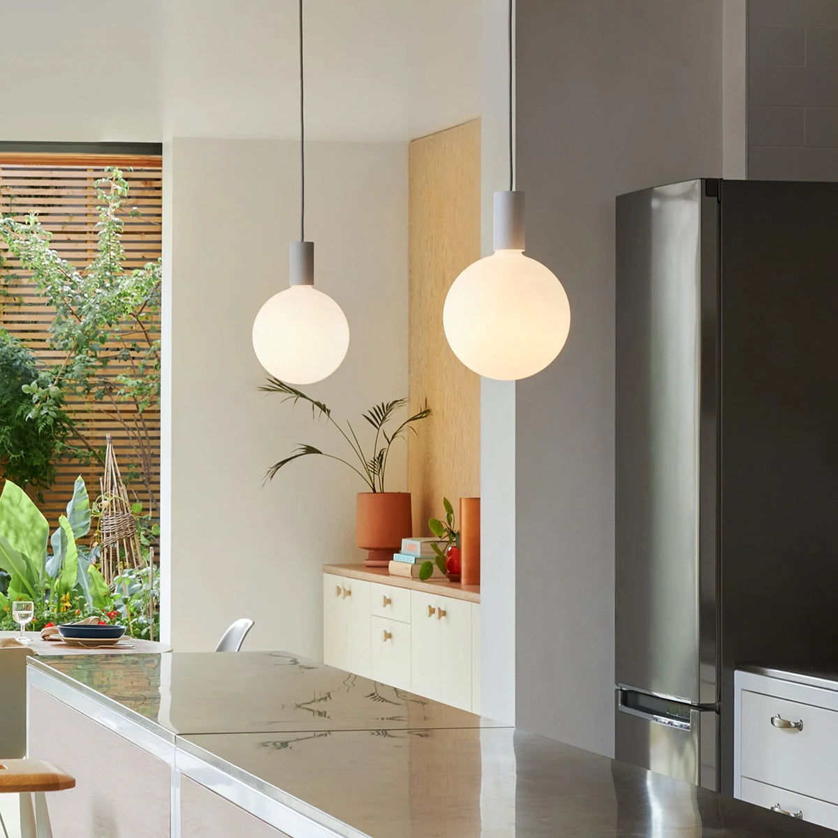 Cylinder pendant with matt white globe bulb, chalk, in a kitchen with a fridge