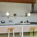 Cylinder pendant with matt white globe bulb, chalk, two above a kitchen counter