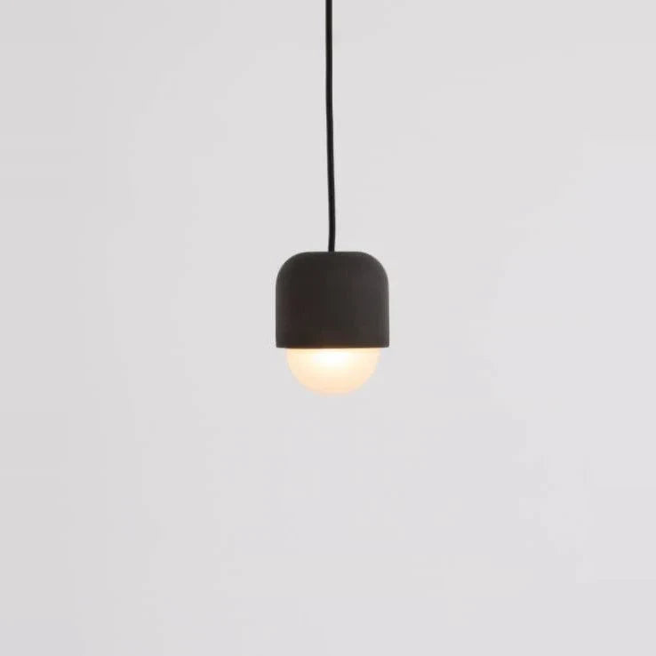 Dark concrete and glass mini pendant, lit, close-up