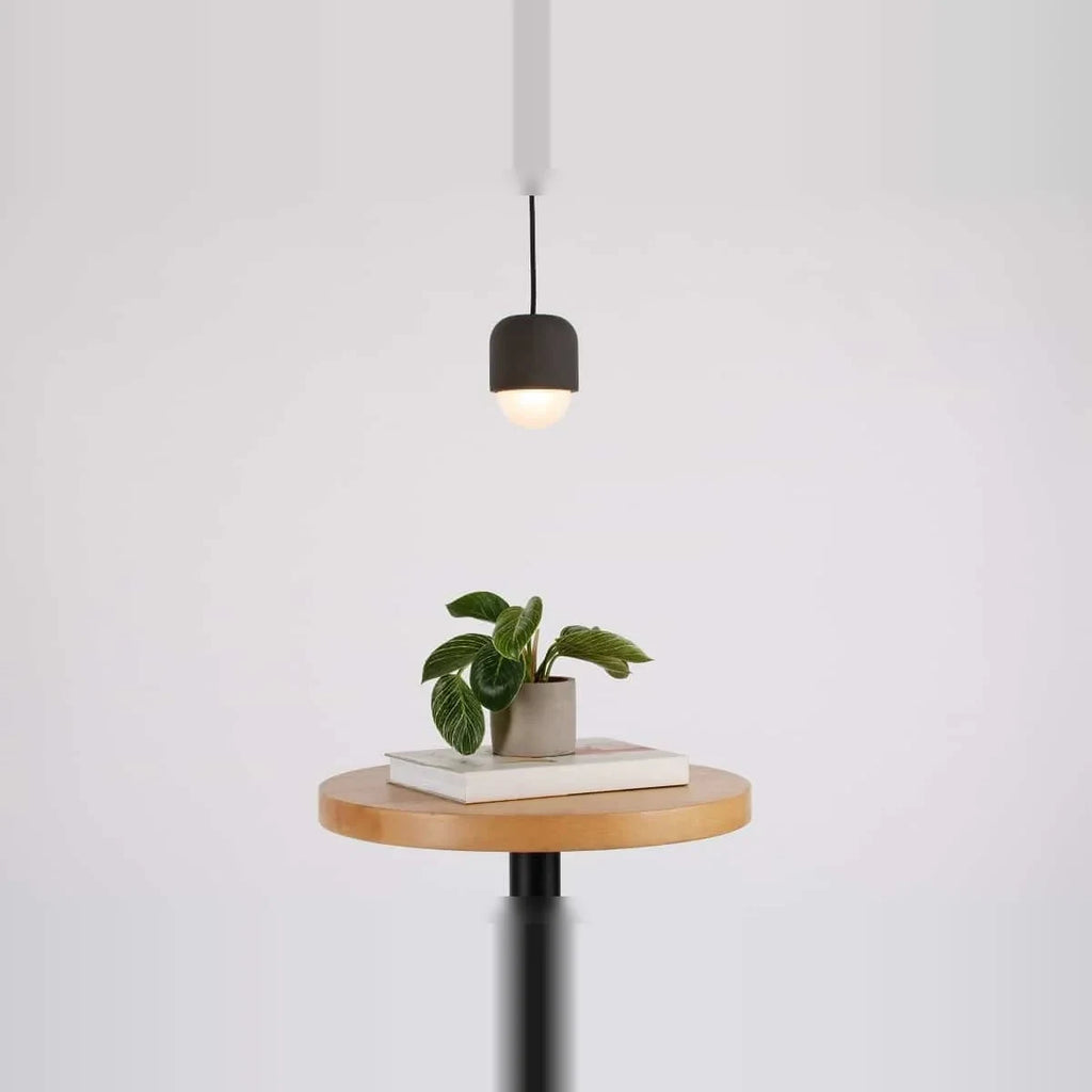 Dark concrete and glass mini pendant, above a round side table