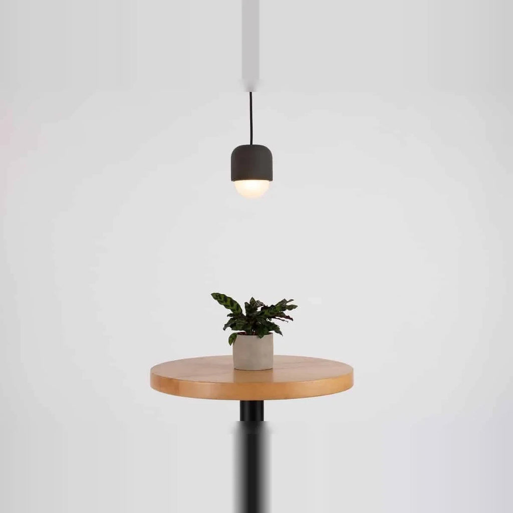 Dark concrete and glass mini pendant, above a side table, lit