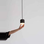 Dark concrete and glass mini pendant, held from below