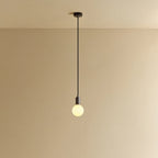 Dim-to-warm globe pendant, graphite, lit, against a plain wall