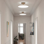 Disc LED ceiling light with brass stem, two lights in a hallway