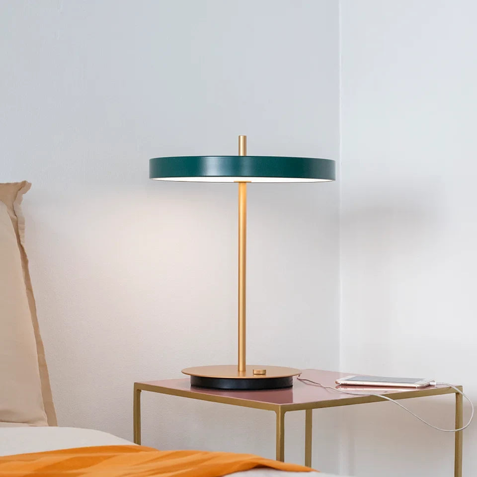 Disc-top LED table lamp with brass stem, in forest green, side view