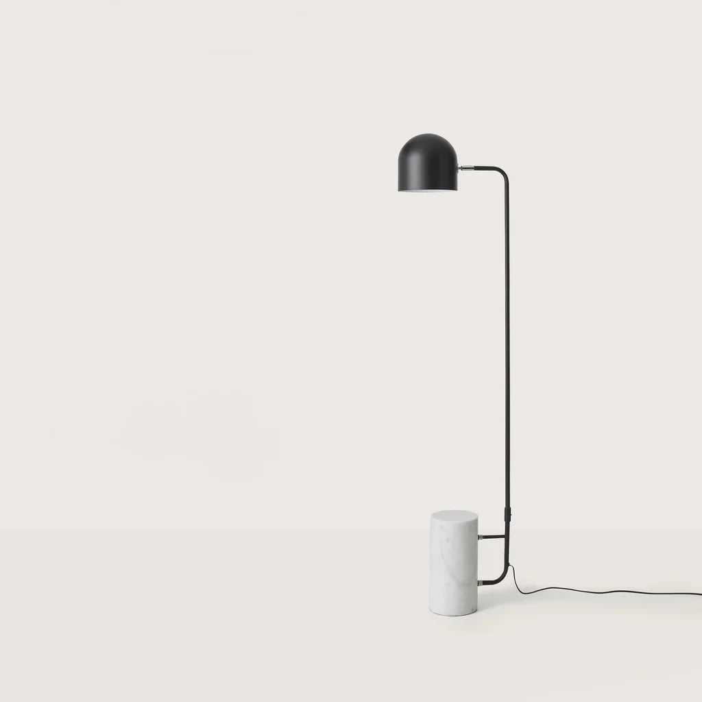 Dome shade reading floor lamp with white marble base, in a room with a bench and framed art