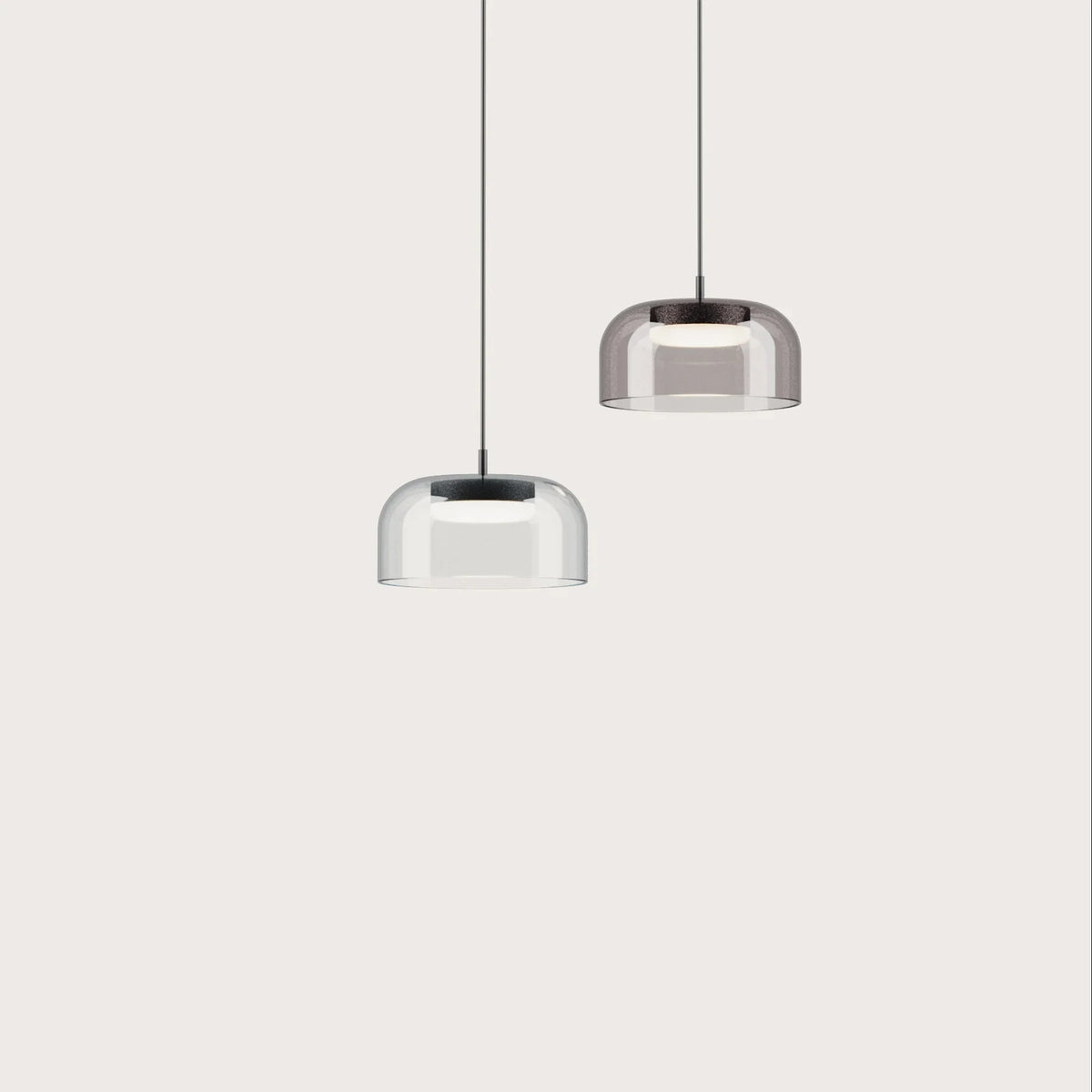 Domed glass pendant with integrated LED, a clear and a smoked shade on a plain background