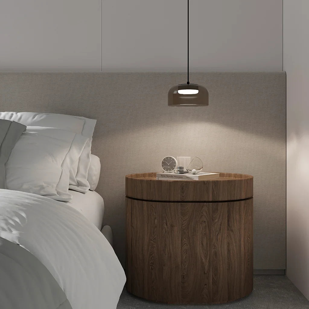 Domed glass pendant with integrated LED, above a bedside table