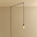 Plug-in pendant with a filament bulb, graphite, lit, hung from a ceiling corner